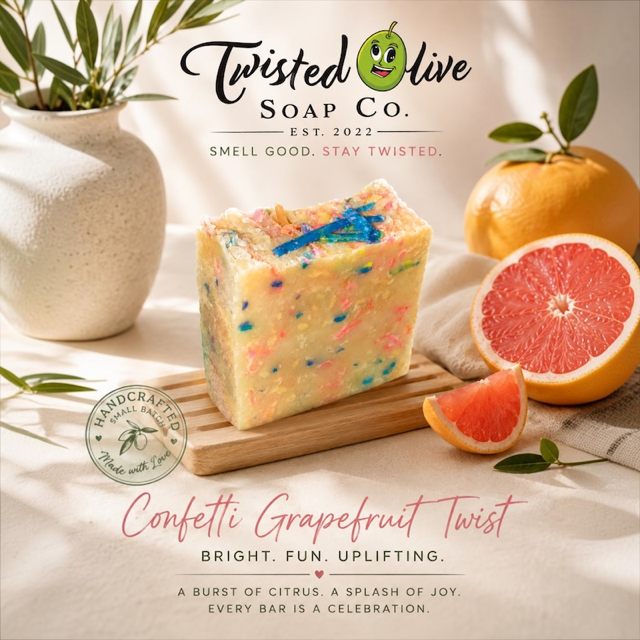 A rectangular bar of handmade soap from Twisted Olive Soap Co. labeled 'Confetti Grapefruit Twist,' The Soap design looks like colored confetti with a yellow base shown on a wooden board with and orange and also a grapefruit half with a grapefruit slice and a vase in the background. Bright · FUn · Uplifting is under the Fragrance name.  A Burst of Citrus. A spash of Joy. Every Bar is  Celebration.  written at the bottom