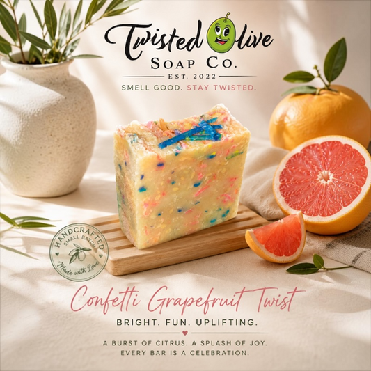 A rectangular bar of handmade soap from Twisted Olive Soap Co. labeled 'Confetti Grapefruit Twist,' The Soap design looks like colored confetti with a yellow base shown on a wooden board with and orange and also a grapefruit half with a grapefruit slice and a vase in the background. Bright · FUn · Uplifting is under the Fragrance name.  A Burst of Citrus. A spash of Joy. Every Bar is  Celebration.  written at the bottom